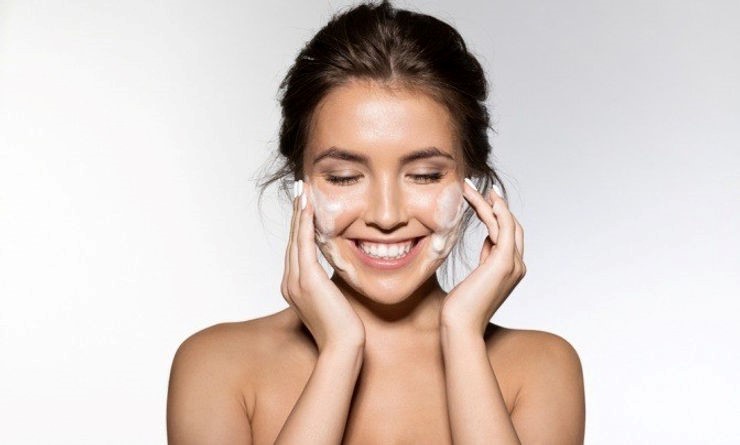 Junge Frau mit wasserfreiem Schaum im Gesicht für die gründliche und schonende Reinigung.