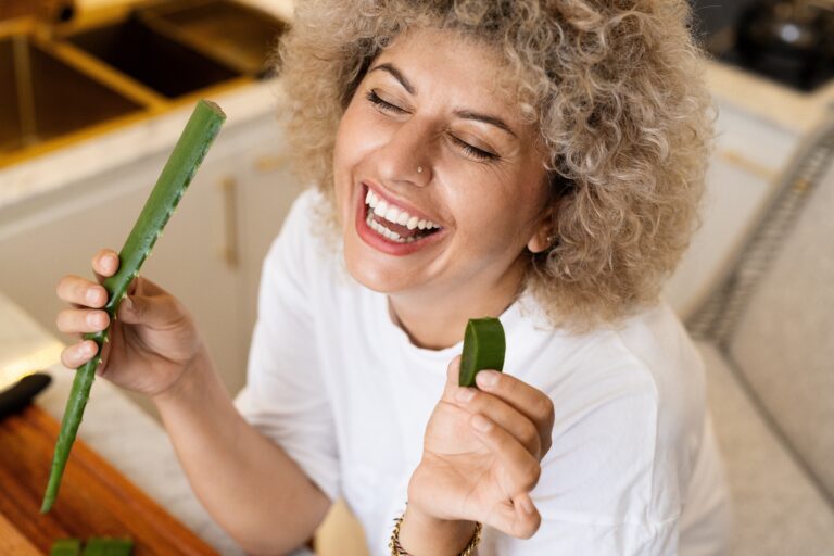 Frau mit Blatt einer Aloe lächelt glücklich